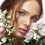 Beautiful woman with classic nude make-up, light hairstyle and flowers. Beauty face.